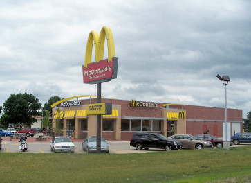 a fast food restaurant with cars parked in front of it