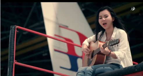 a woman sitting on a boxing ring playing a guitar